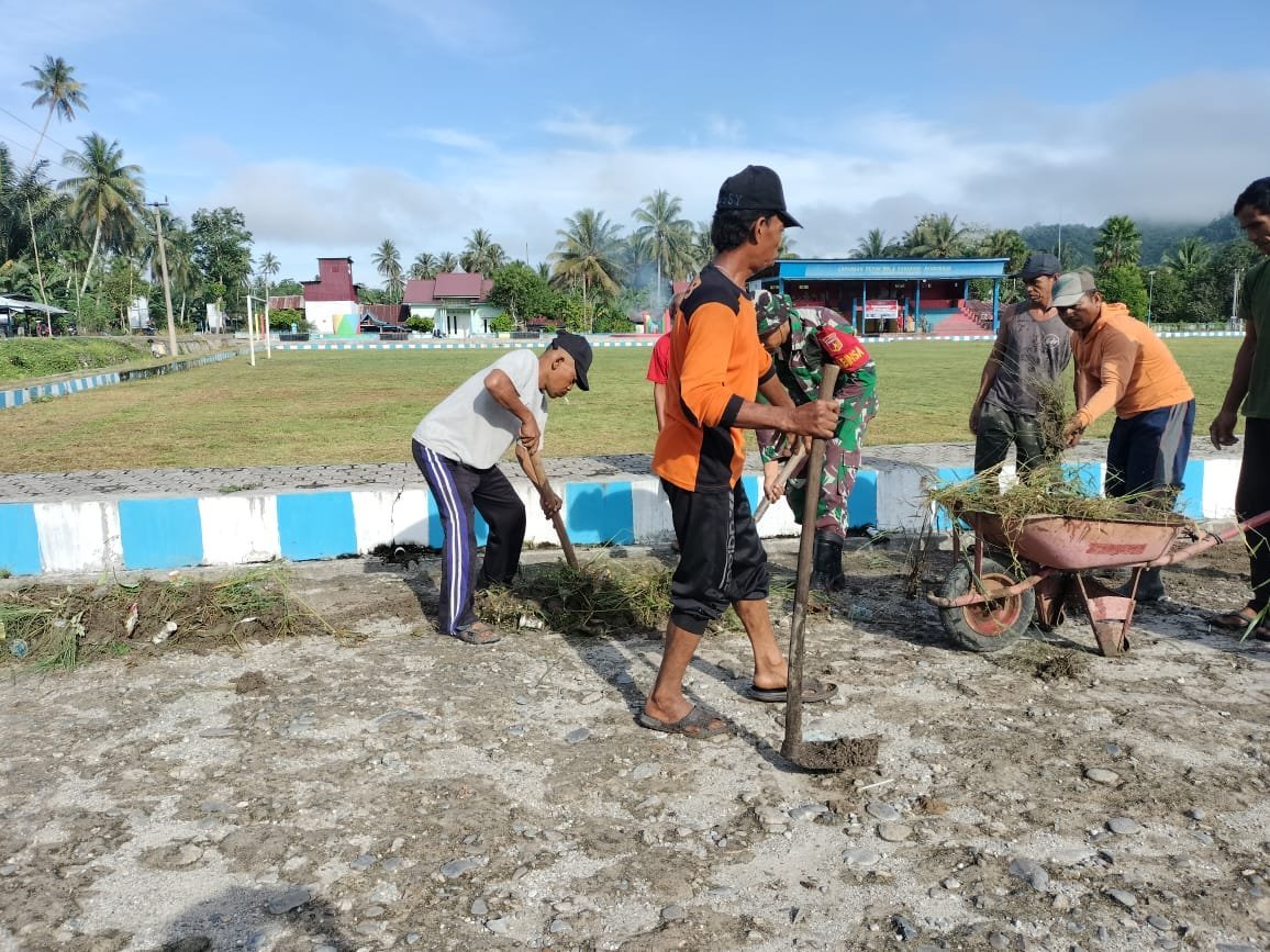 Babinsa Koramil 01 Baolan Bersama Masyarakat Bersihkan Saluran Air di Seputaran Lapangan Desa Salugan