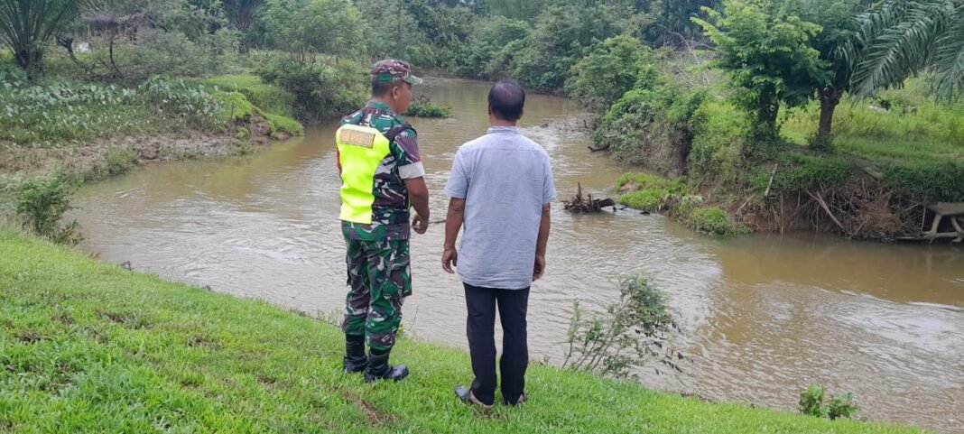 Antisipasi Banjir, Babinsa Pantau Kondisi Sungai Bersama Warga