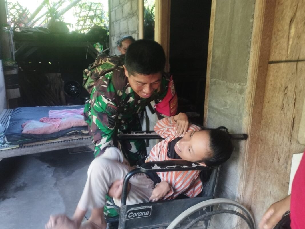 Bukti Nyata TNI Cinta Rakyat, Anggota Koramil Dawan Gendong Warga Lumpuh Terima Bantuan