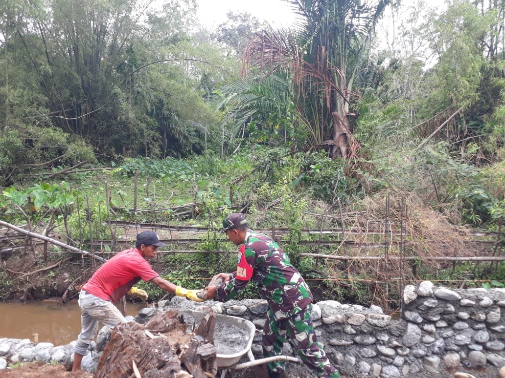 Bangun Tanggul Penahan Jalan di Desa Cot Pluh Serda M. Sofyan Turun Langsung Bantu Angkat Batu dan Adukan Semen