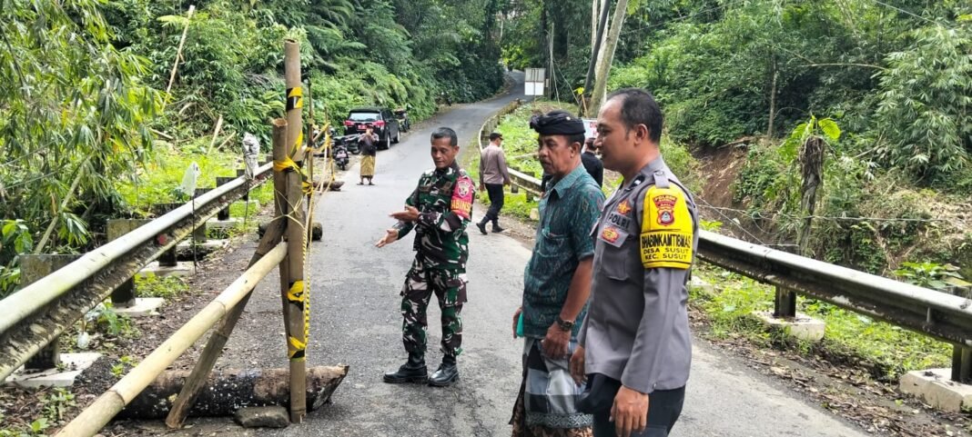 Babinsa Desa Susut Bersama Bhabinkamtibmas Pasang Police Line di Lokasi Longsor Bahu Jembatan