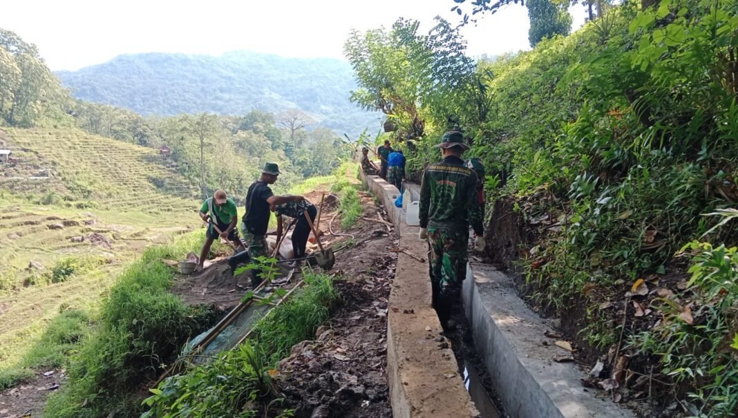 Anggota Kodim 1612/Manggarai Bersama Warga Bangun Saluran Irigasi Waelenteng dalam Rangka TMMD ke-126 di Desa Pinggang