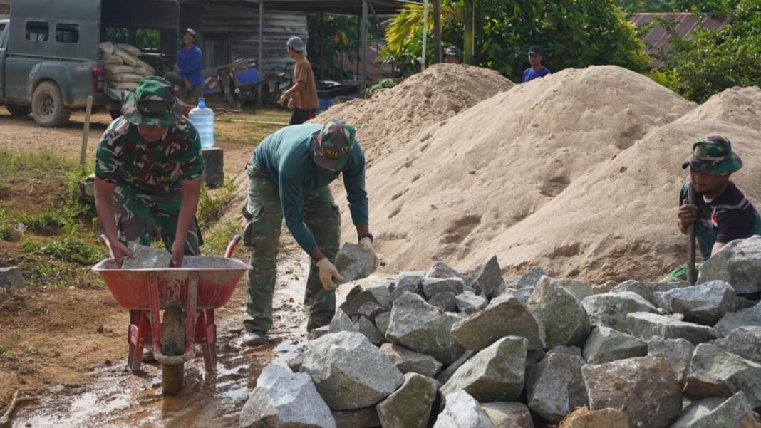 Sinergi Satgas TMMD dan Warga Desa Tribuana Dalam Angkut Material Batu Belah