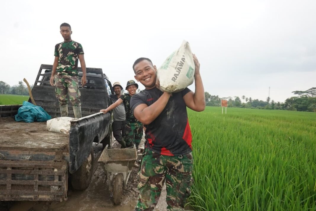 Semangat Ramadan: Satgas TMMD Angkat Berat Karung Semen dengan Ikhlas