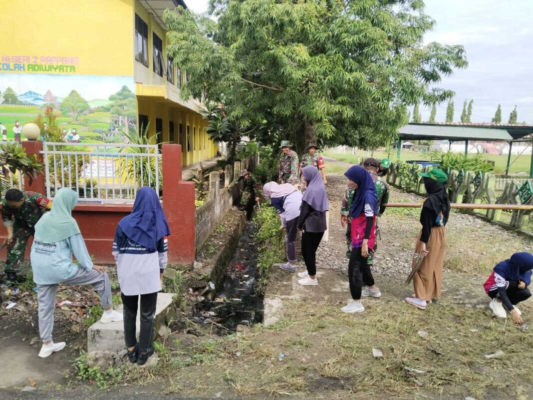 Upaya Bersama Antisipasi Banjir, Babinsa Maccorawalie Ajak Warga Bersihkan Saluran Air