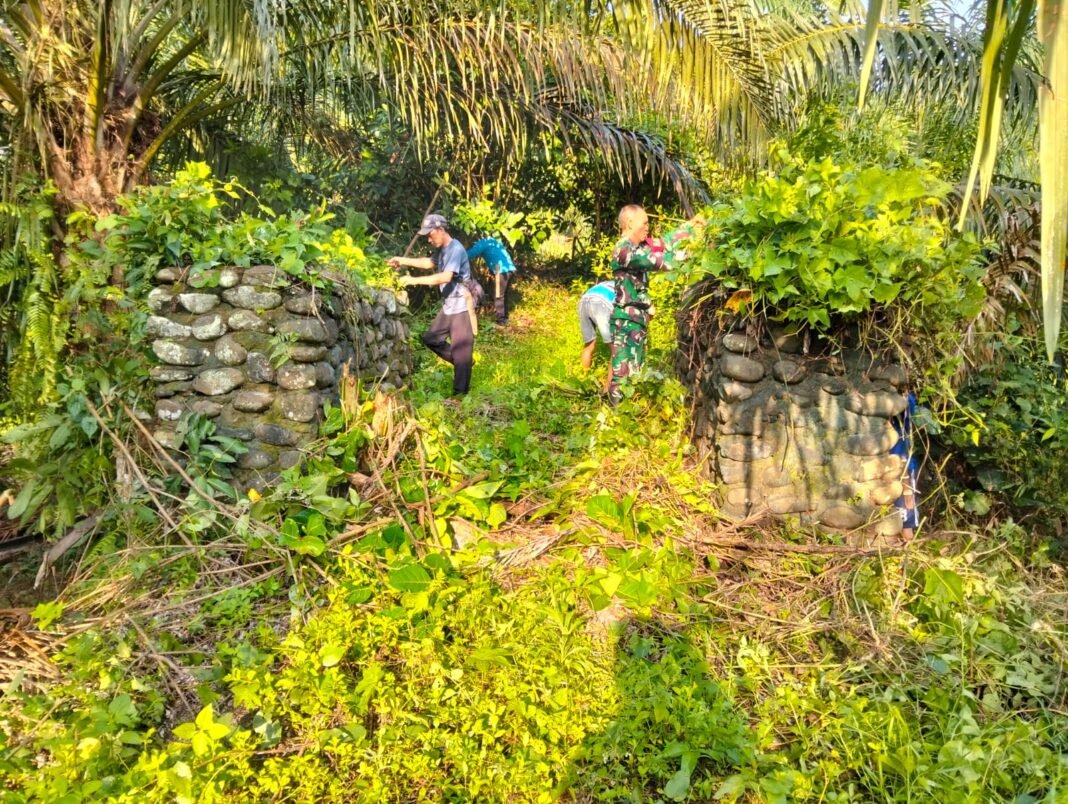 Babinsa Koramil 425-05/Ulu Talo Bersinergi dengan Masyarakat dalam Pembersihan Area Jembatan