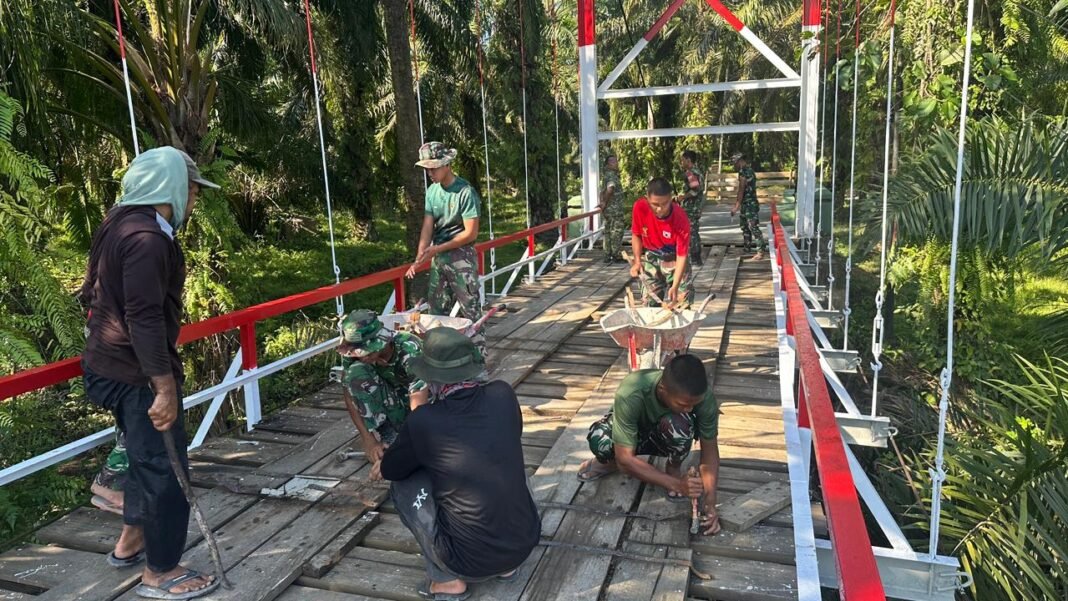 Rampungkan Perehaban Jembatan Gantung Perintis Garuda, Personel Kodim 0428/Mukomuko Laksanakan Perbaikan badan jembatan dan Pengecatan Loneng