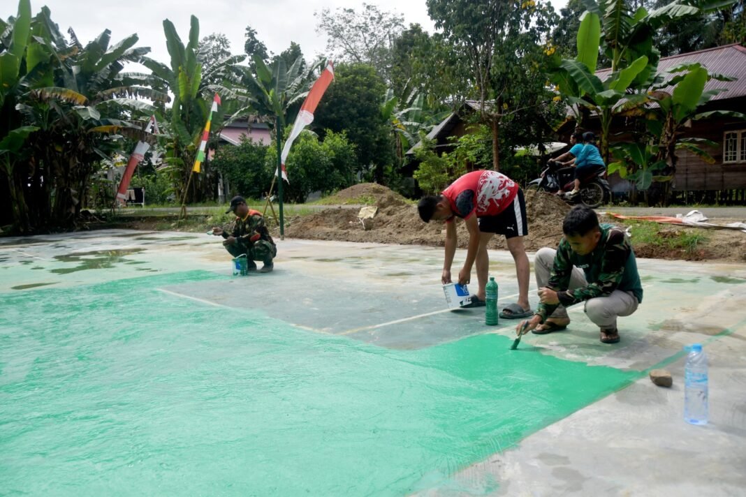 TNI dan Warga Kompak Cat Lapangan Voli, Wujud Kemanunggalan di TMMD 128 Kodim 1003/HSS