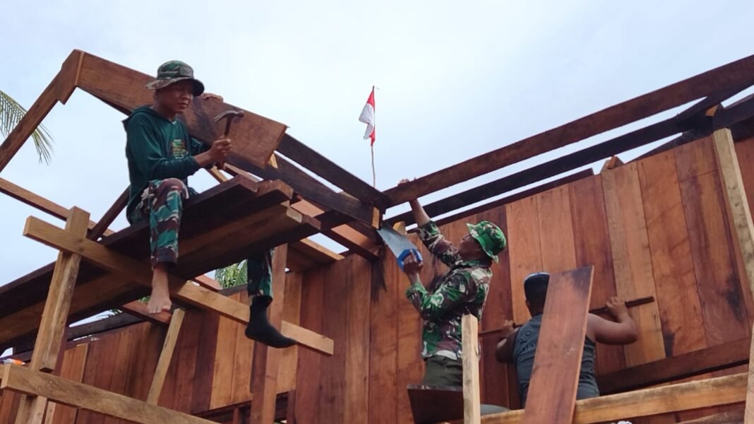 Kegiatan Pemasangan dan Pengecatan Lisplang di Rumah Niko Makare oleh TMMD Ke-128