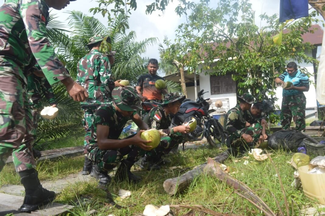 Hilangkan Dahaga, Anggota Satgas TMMD Istirahat Sambil Minum Kelapa Muda