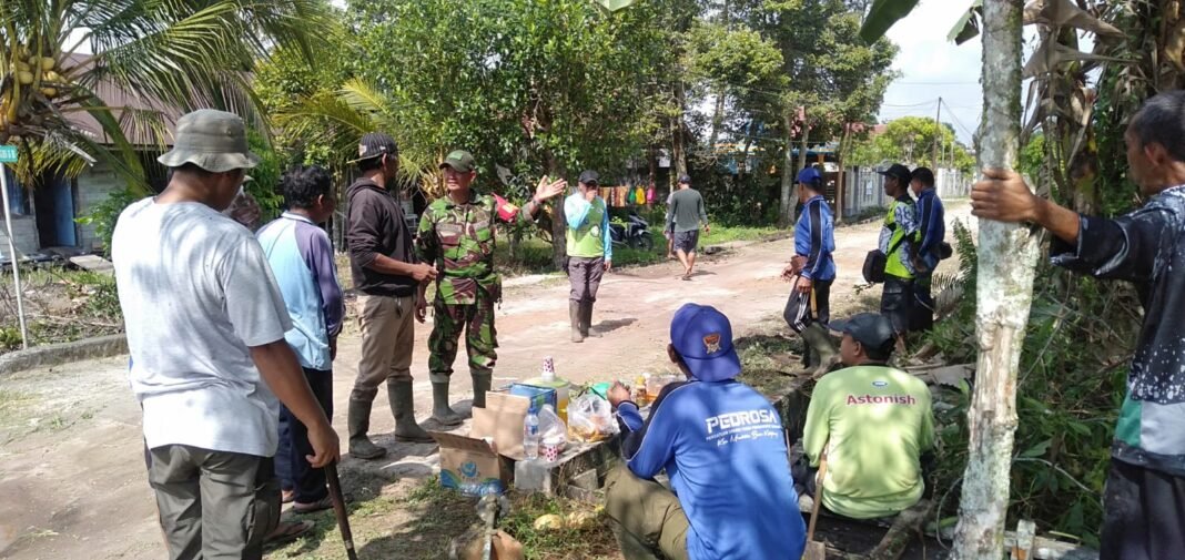 Kerja Sama Babinsa dan Masyarakat dalam Membersihkan Parit