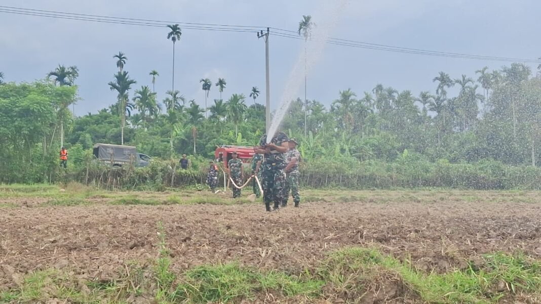 Penyiraman Benih Jagung oleh Satgas TMMD di Tengah Cuaca Panas
