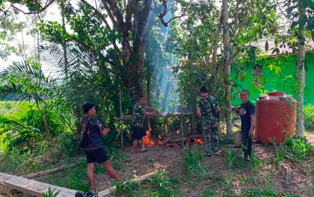 Anggota Satgas TMMD Terlibat Dalam Pembuatan Salai Ikan Bersama Desa Belatung