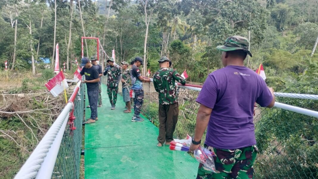 Puluhan Bendera Menyambut Jembatan Gantung TMMD Ke-129 di Bone