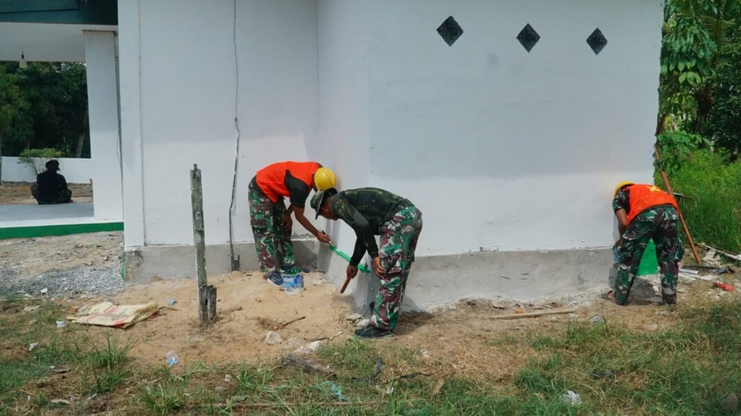 Musholla Darul Iman Menuju Finishing, Satgas TMMD Ke-129 Lakukan Pengecatan Pondasi
