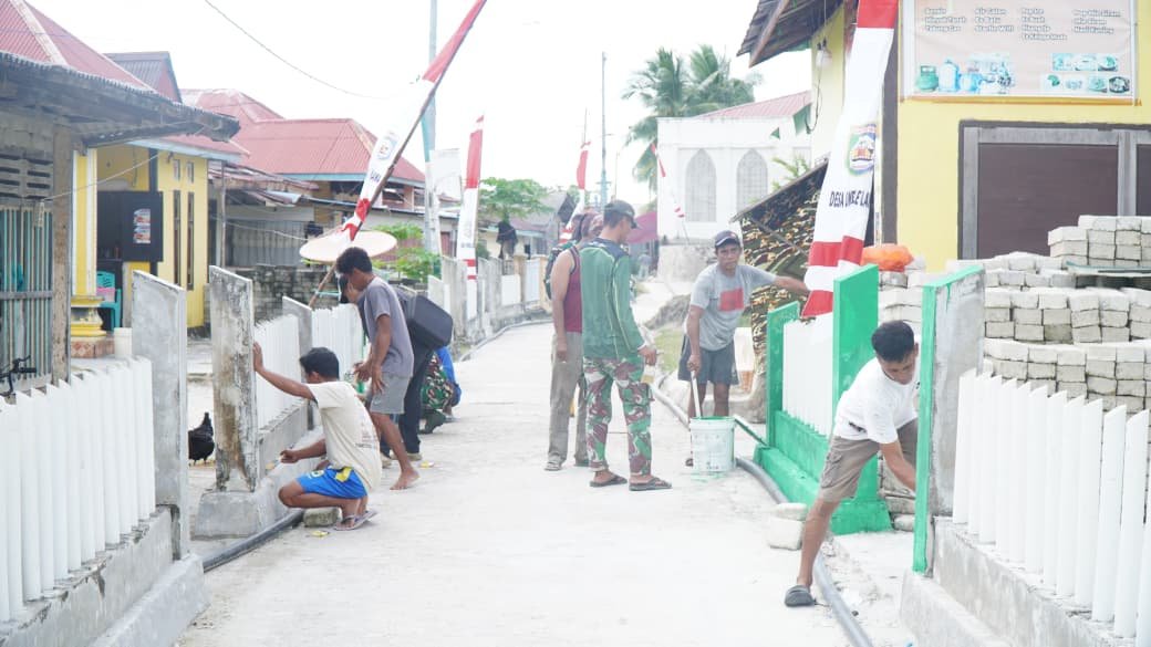 Partisipasi Masyarakat dalam Pengecatan Pagar di Desa Umbele