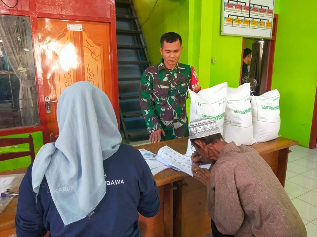 Pastikan Ketertiban, Serka Lalu Agus Kawal Pembagian Bantuan Pangan di Desa Berare